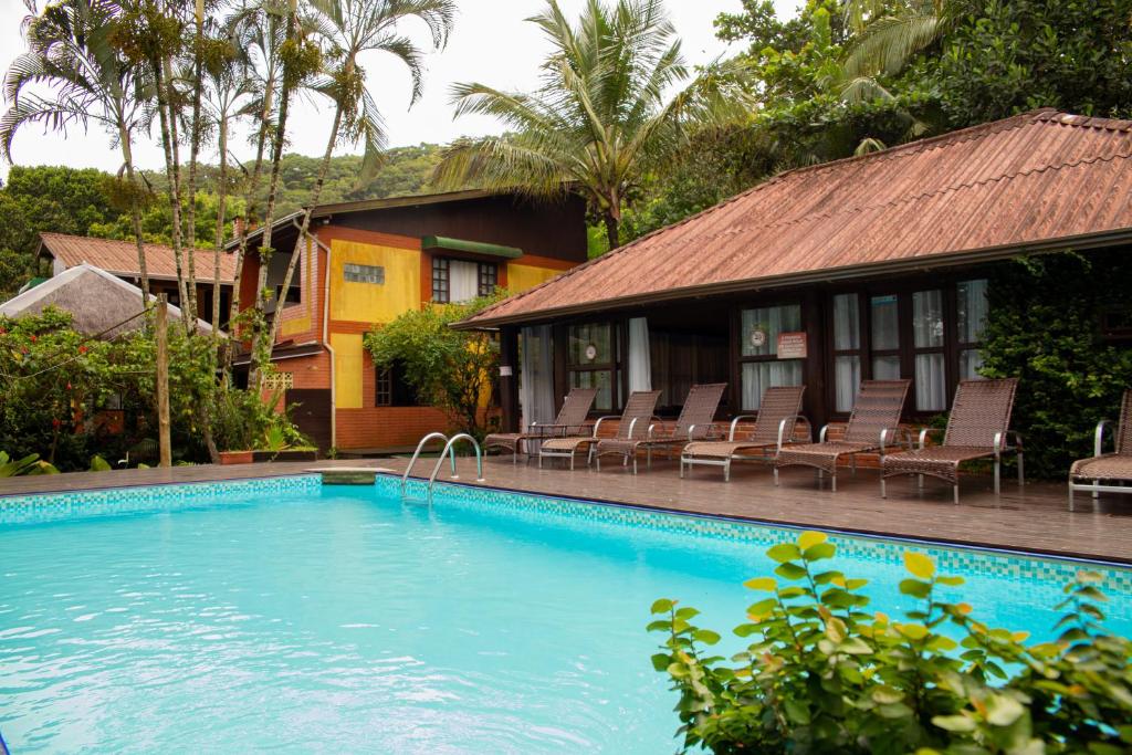 a swimming pool in front of a house at Pousada Éphira in Ilha do Mel