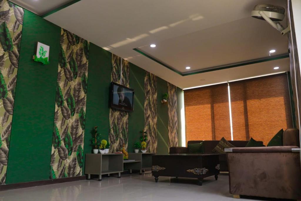 a lobby with a green wall with a waiting room at Greenland 2 Bedroom Apartment in Lahore