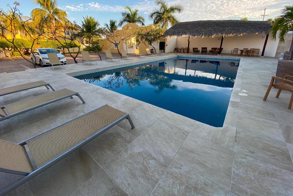 een zwembad met stoelen en een huis bij Condominios JAROJE in Santa Cruz Huatulco