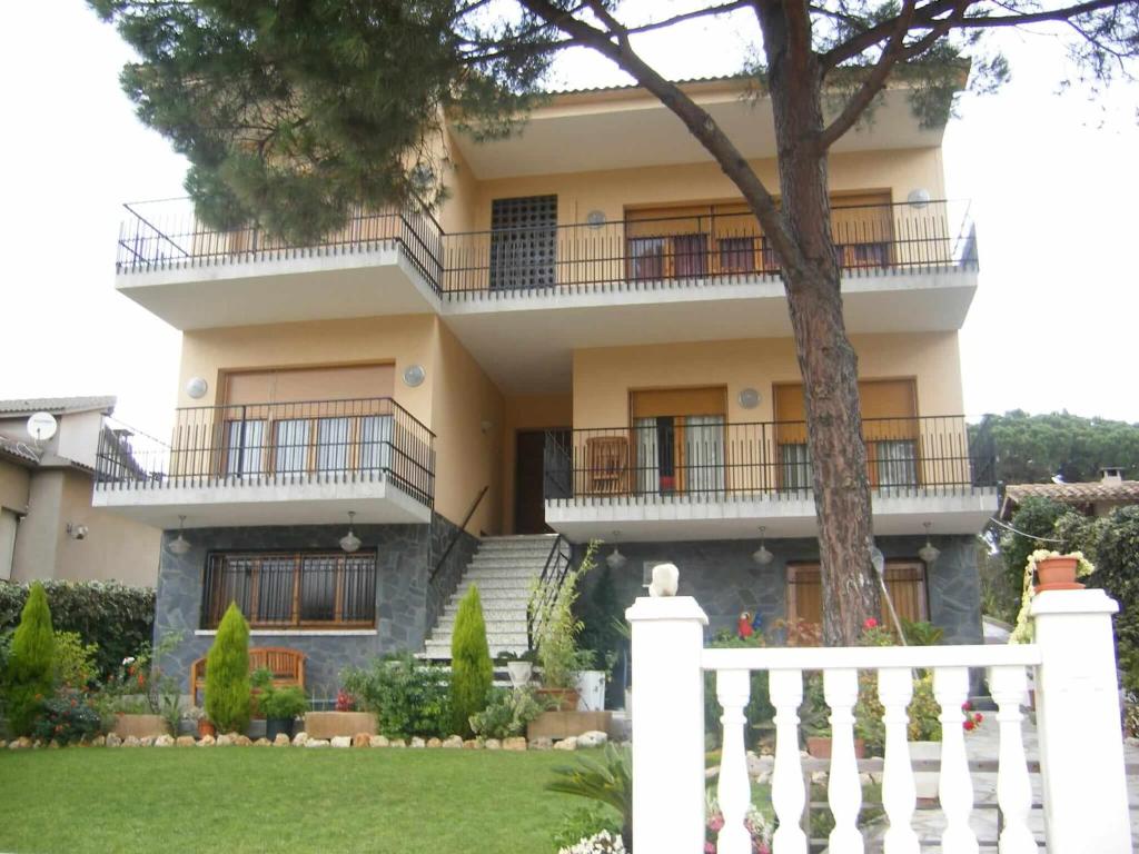 une maison avec une clôture blanche devant elle dans l'établissement Habitaciones en Villa Coliving Casa Rural, à San Fausto de Campcentellas