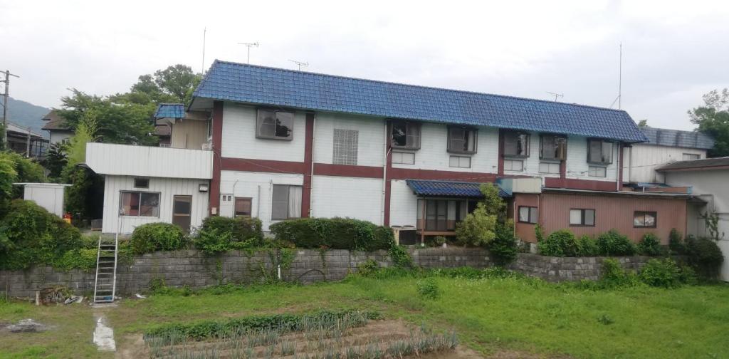 a white house with a blue roof and a yard at Suijin Hotel - Vacation STAY 23120v in Chichibu