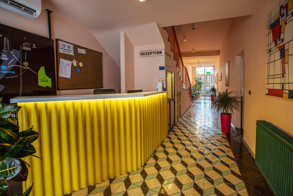 a yellow bar in a room with a hallway at Hotel 4 Llulla in Pristina