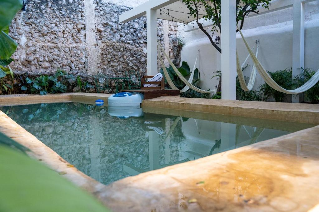 a pool of water with a shower and a tub at Hotel & Hostal Boutique Casa Garza in Mérida