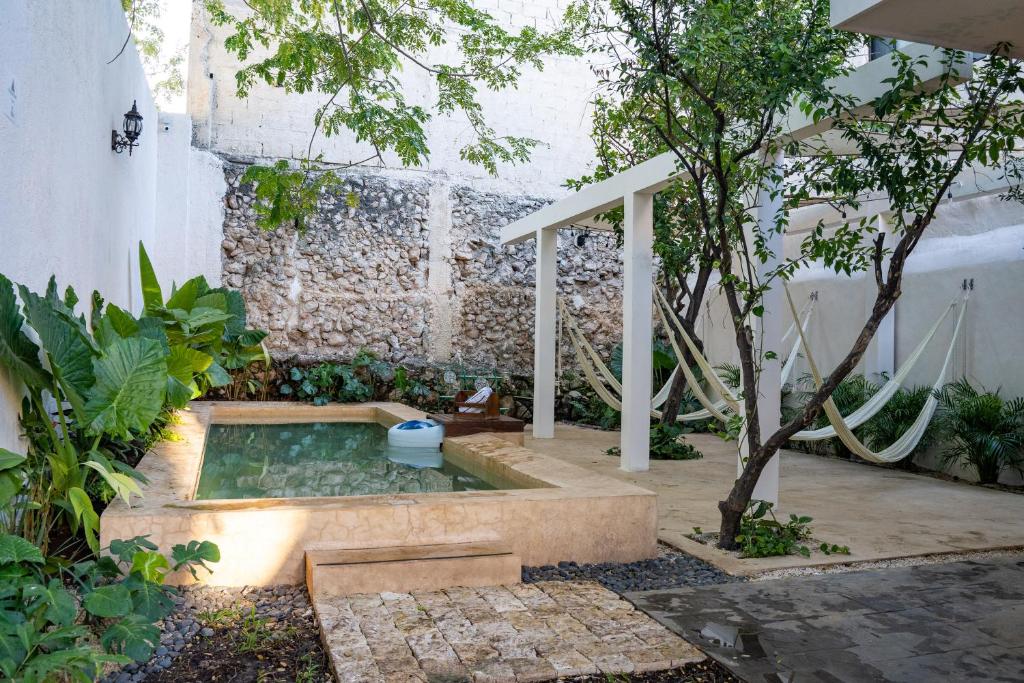 a garden with a hot tub in the middle of a yard at Hotel & Hostal Boutique Casa Garza in Mérida