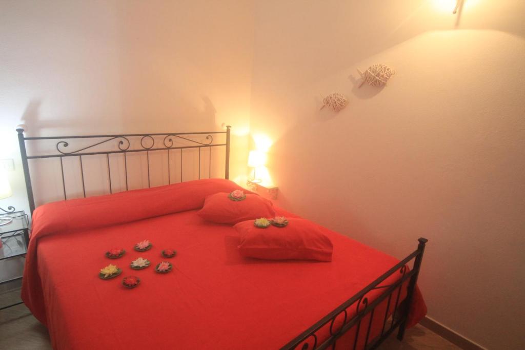 a bedroom with a red bed with rings and shoes on it at Vernazza Vacation 2 in Vernazza