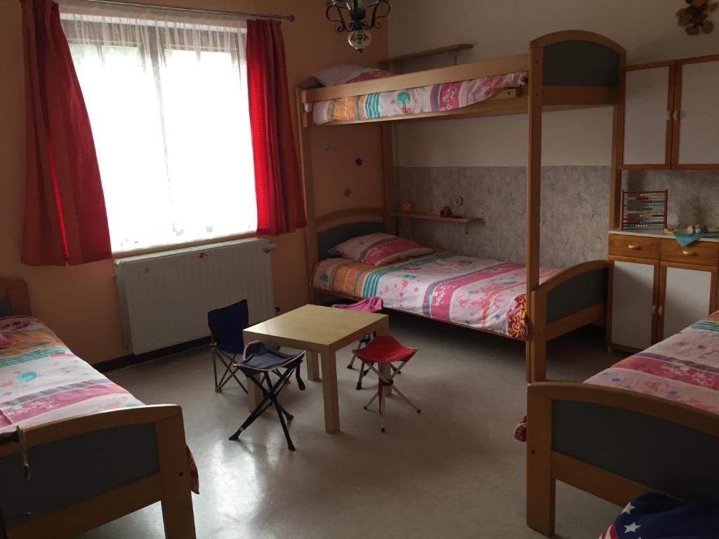 a bedroom with two bunk beds and a table and chairs at Le Valdine in Jemeppe