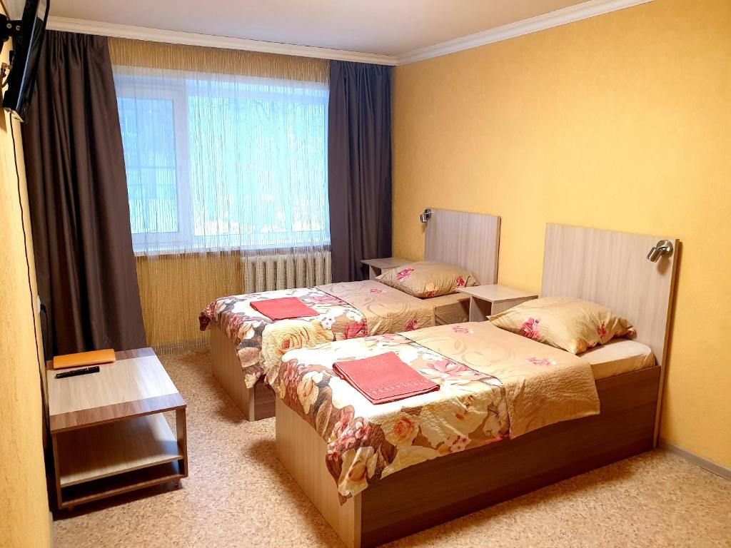 アルハンゲリスクにあるYanemezStayのベッド2台と窓が備わるホテルルームです。
