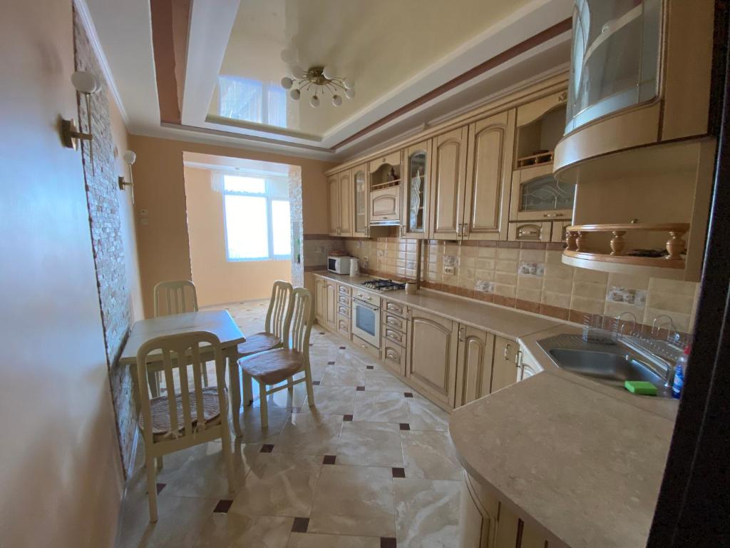 a kitchen with wooden cabinets and a table and chairs at Luxury apartment 2 in Truskavets