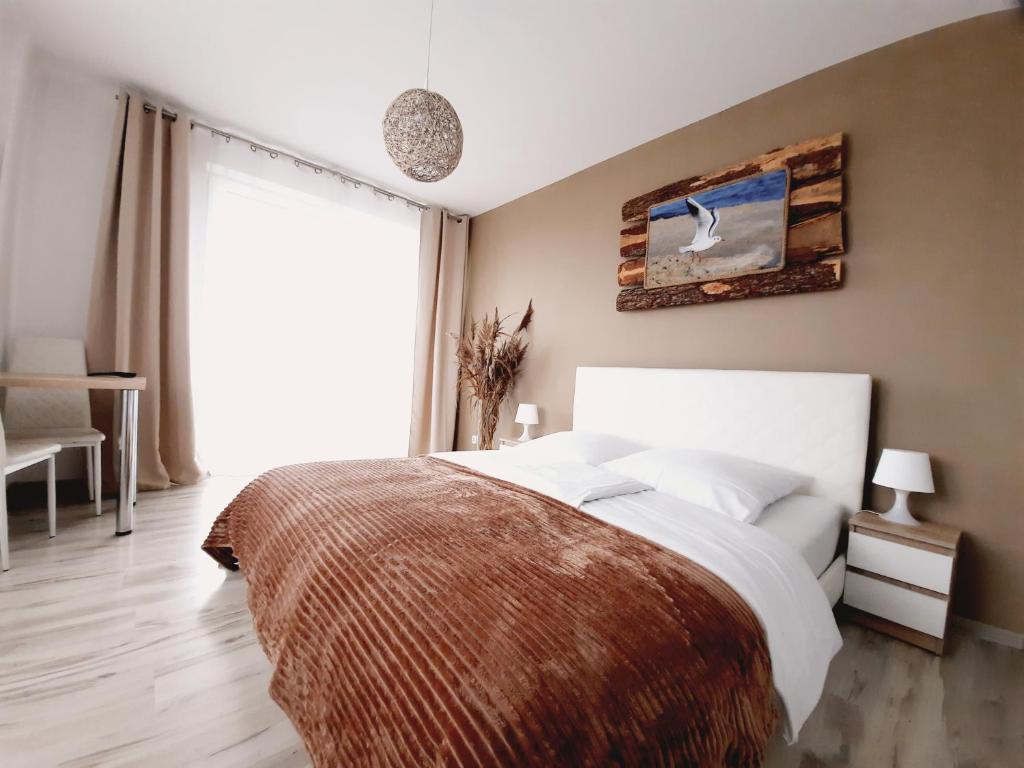 Un dormitorio con una cama grande y una ventana en Willa Baltycka Bryza en Władysławowo