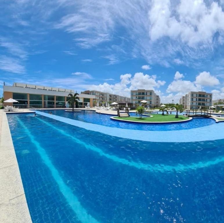 uma grande piscina com água azul em frente a um edifício em Muro Alto Condomínio Clube - Porto de Galinhas em Porto de Galinhas