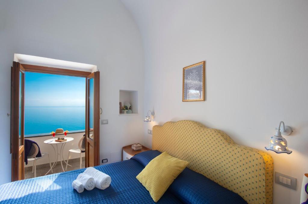 una camera con letto e vista sull'oceano di APPARTAMENTO MOON LIGHT ad Amalfi