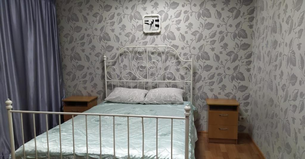 a bedroom with a bed with a metal bed frame at Hotel Kuibyshevskaya in Novokuznetsk