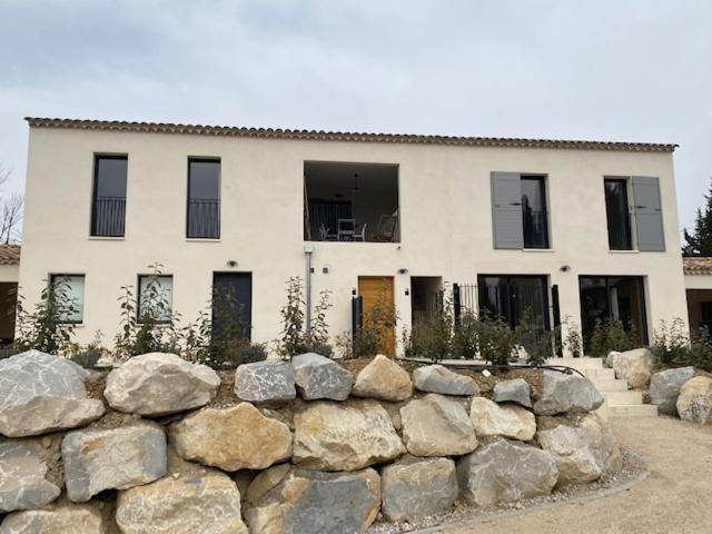 a large white house behind a stone wall at Les Palivettes 2.1 in Malaucène