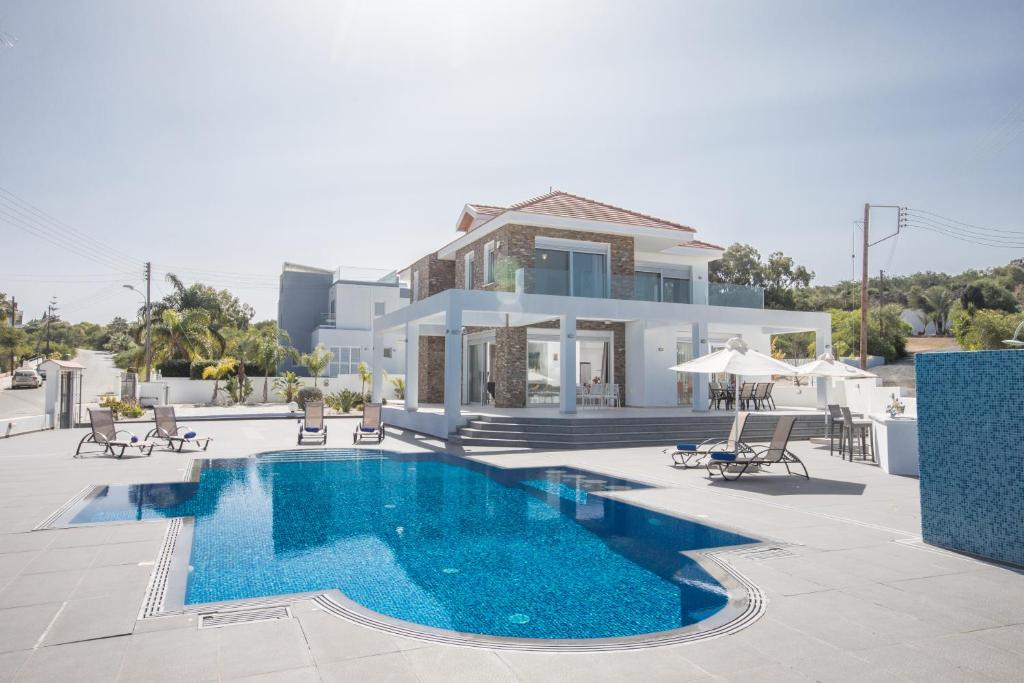 uma villa com piscina em frente a uma casa em Villa Gardenia em Protaras