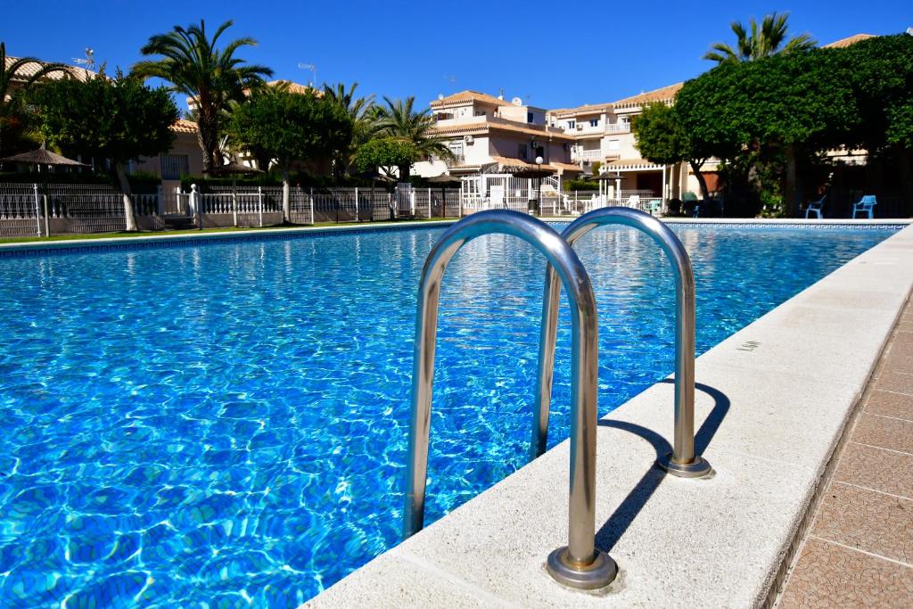 a swimming pool with blue water in a resort at Apartamento Casa Prima in Playa Flamenca
