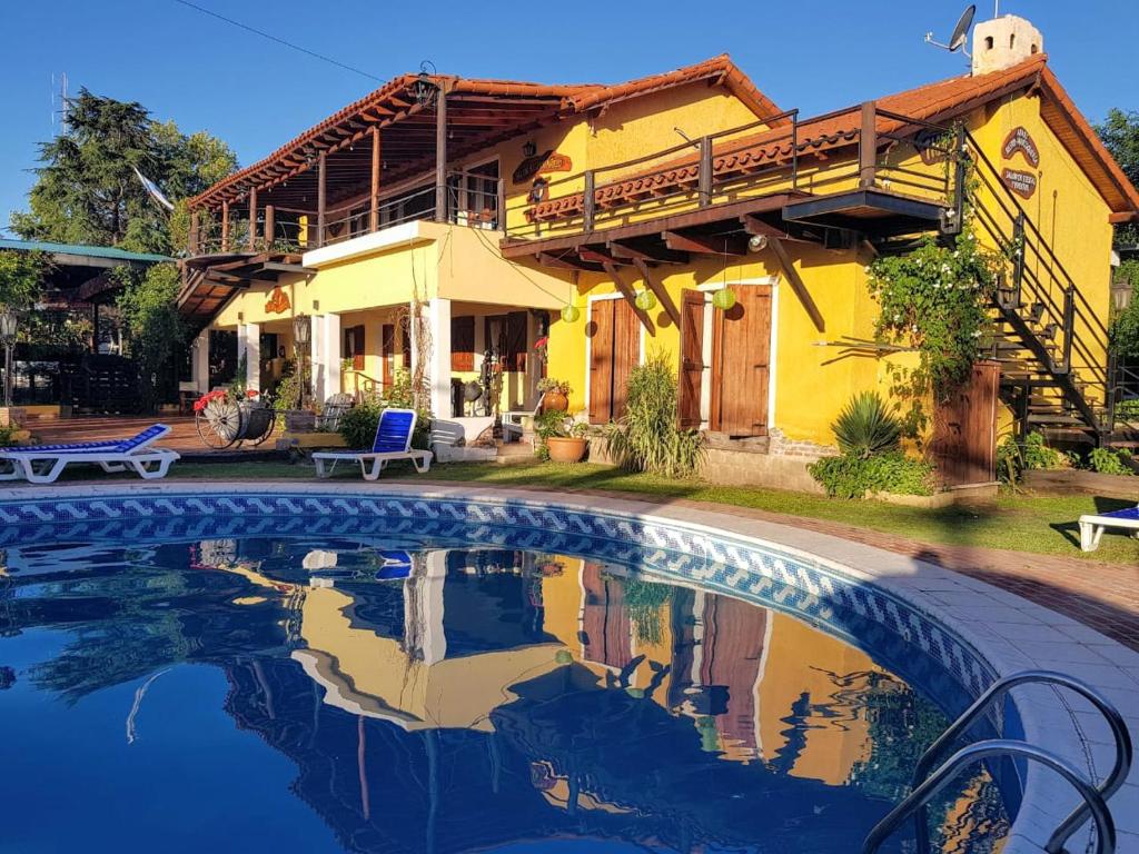 una casa con piscina frente a una casa en Tico Tico Apart en Mina Clavero