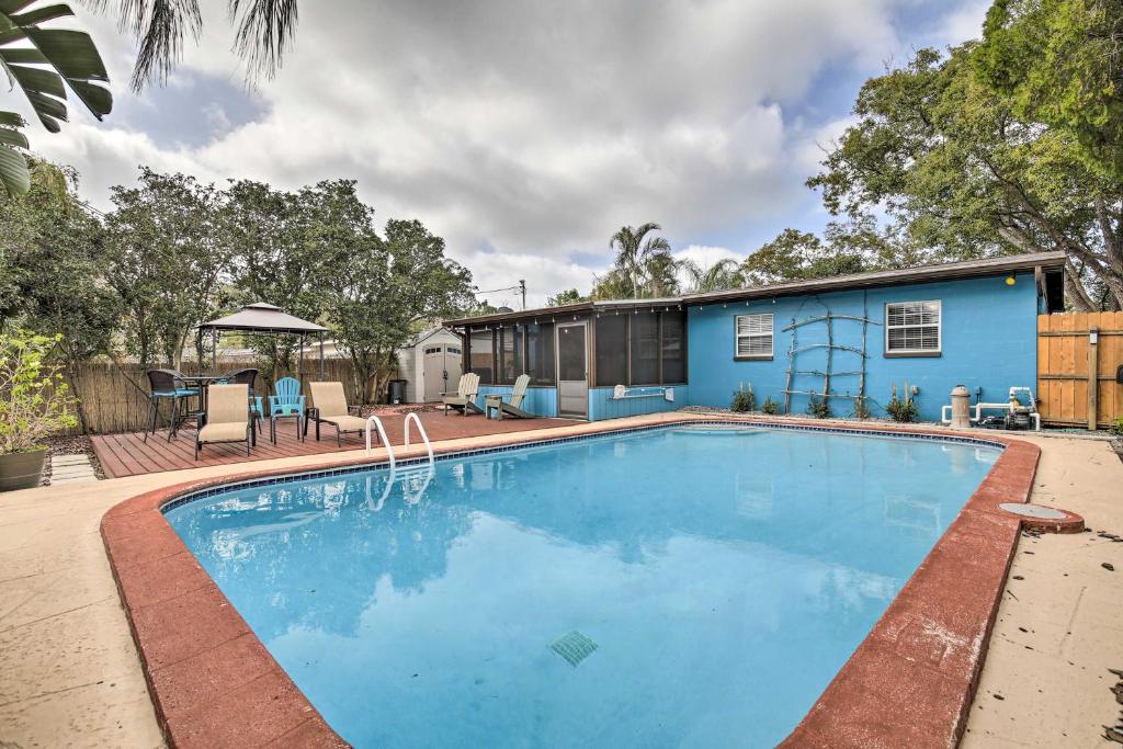 a swimming pool in front of a house at Tropical Palm Harbor Retreat with Lanai and Patio! in Palm Harbor