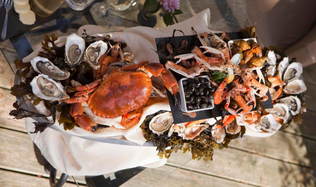 a plate of seafood and oysters on a table at Hôtel Restaurant & Spa Plaisir in Le Bois-Plage-en-Ré