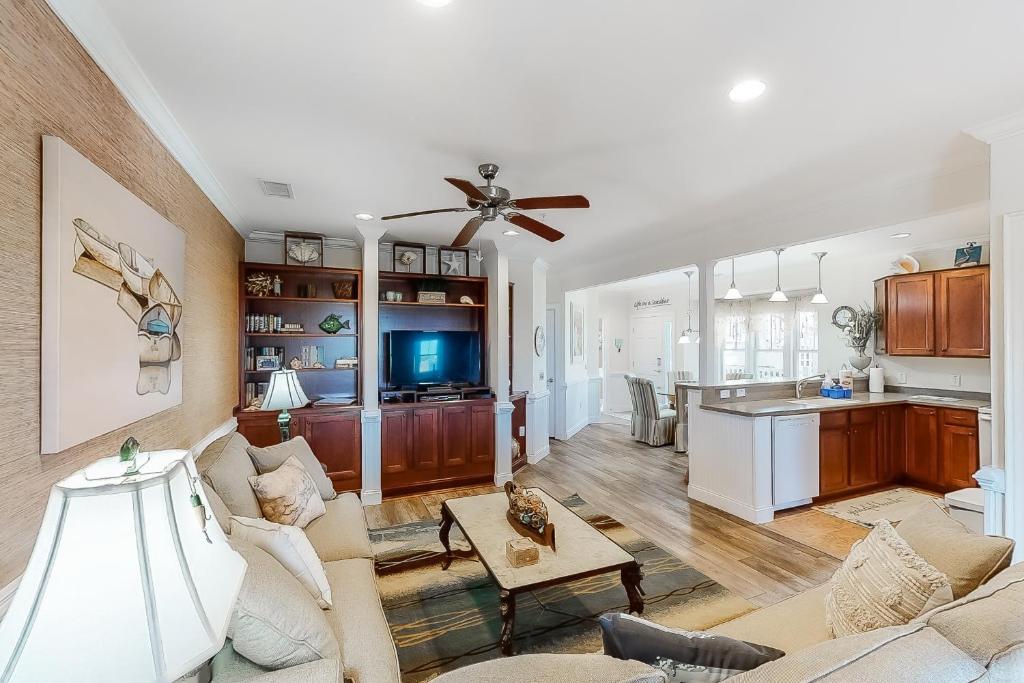 a living room and kitchen with a ceiling fan at Sunrise Paradise in Hatteras