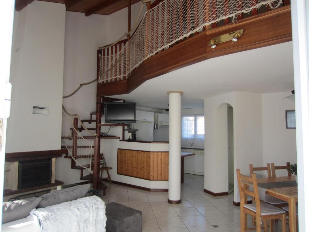 ein Wohnzimmer mit einer Wendeltreppe und einem Tisch in der Unterkunft Maison LES SABLES D'OLONNE 700 m Plage WIFI in La Pironnière