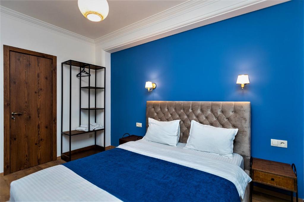 een blauwe slaapkamer met een bed met een blauwe muur bij B&B Old Tbilisi in Tbilisi City