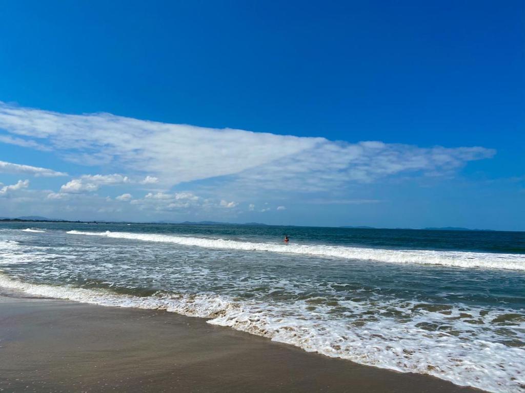 a person standing in the water at the beach at La Ensenada Beach Resort in Tela