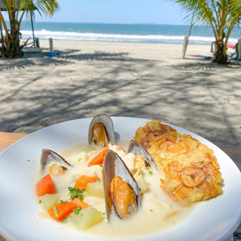 a plate of food with seafood on the beach at La Ensenada Beach Resort in Tela