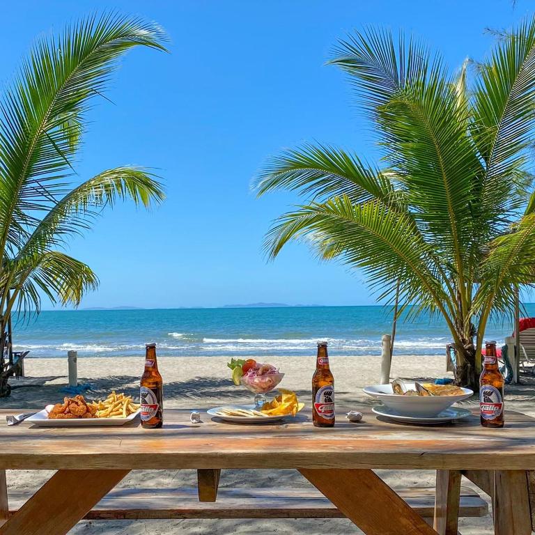 a picnic table on the beach with drinks and food at La Ensenada Beach Resort in Tela