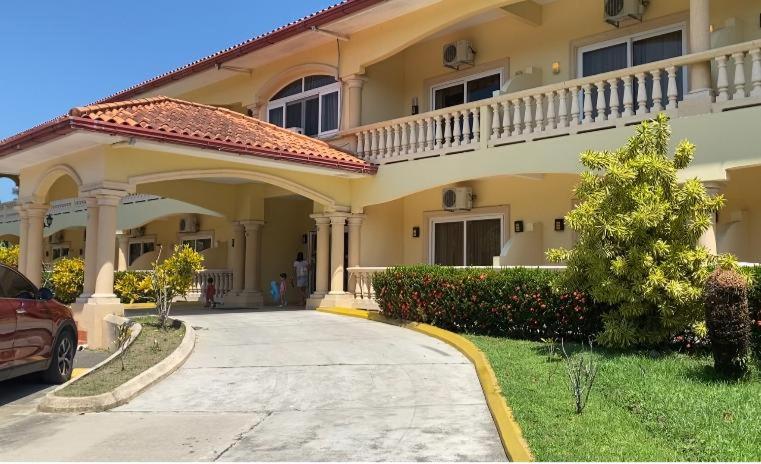 a large house with a car parked in the driveway at La Ensenada Beach Resort in Tela