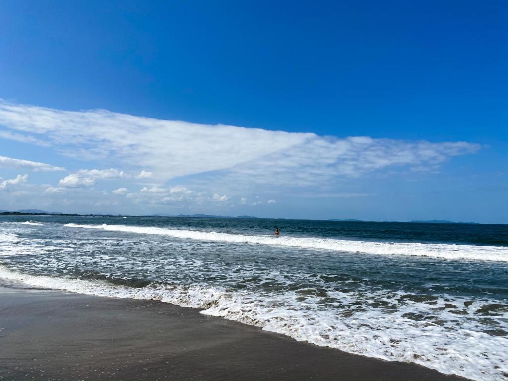 a person standing in the water at the beach at La Ensenada Beach Resort in Tela