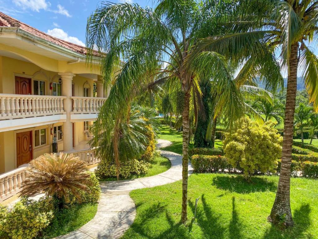 an exterior view of a house with palm trees at La Ensenada Beach Resort in Tela