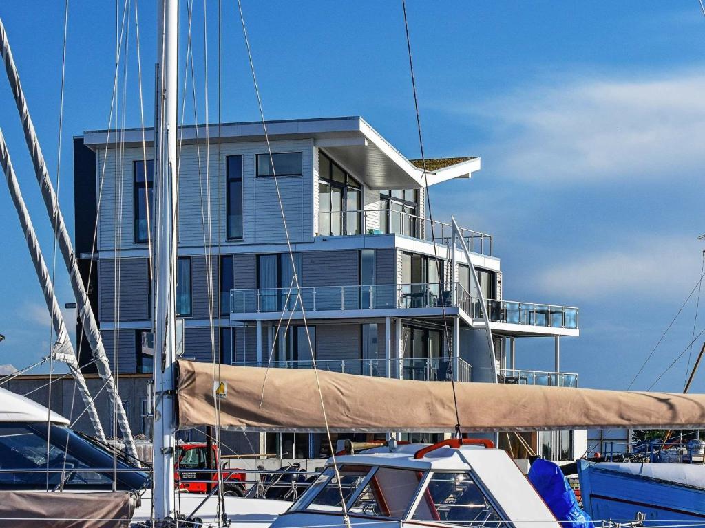 a large building behind boats in a marina at Two-Bedroom Holiday home in Wendtorf 25 in Wendtorf