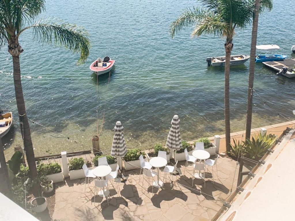 einen Tisch und Stühle mit einem Boot im Wasser in der Unterkunft Pasadena Sydney in Church Point