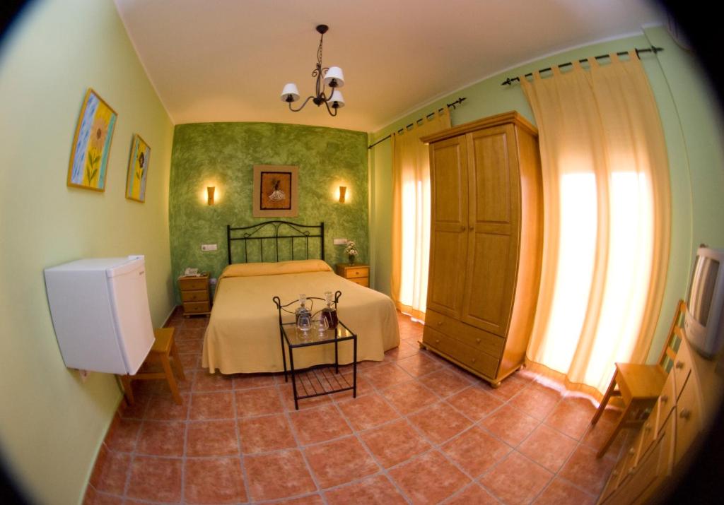 a bedroom with a bed and a table at Hotel Rural El Arriero in La Zarza