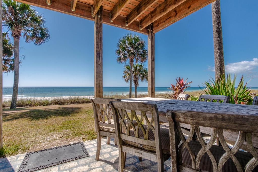 a table and chairs on a patio with the beach at Sunny Beach by Book That Condo in Panama City Beach