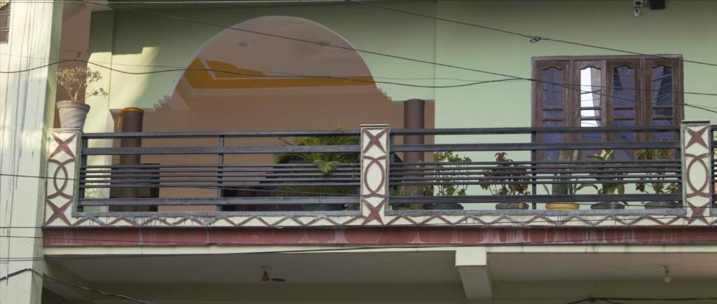 瑞詩凱詩的住宿－Madhuvan Home stay，带阳台的建筑,有坐在上面的人