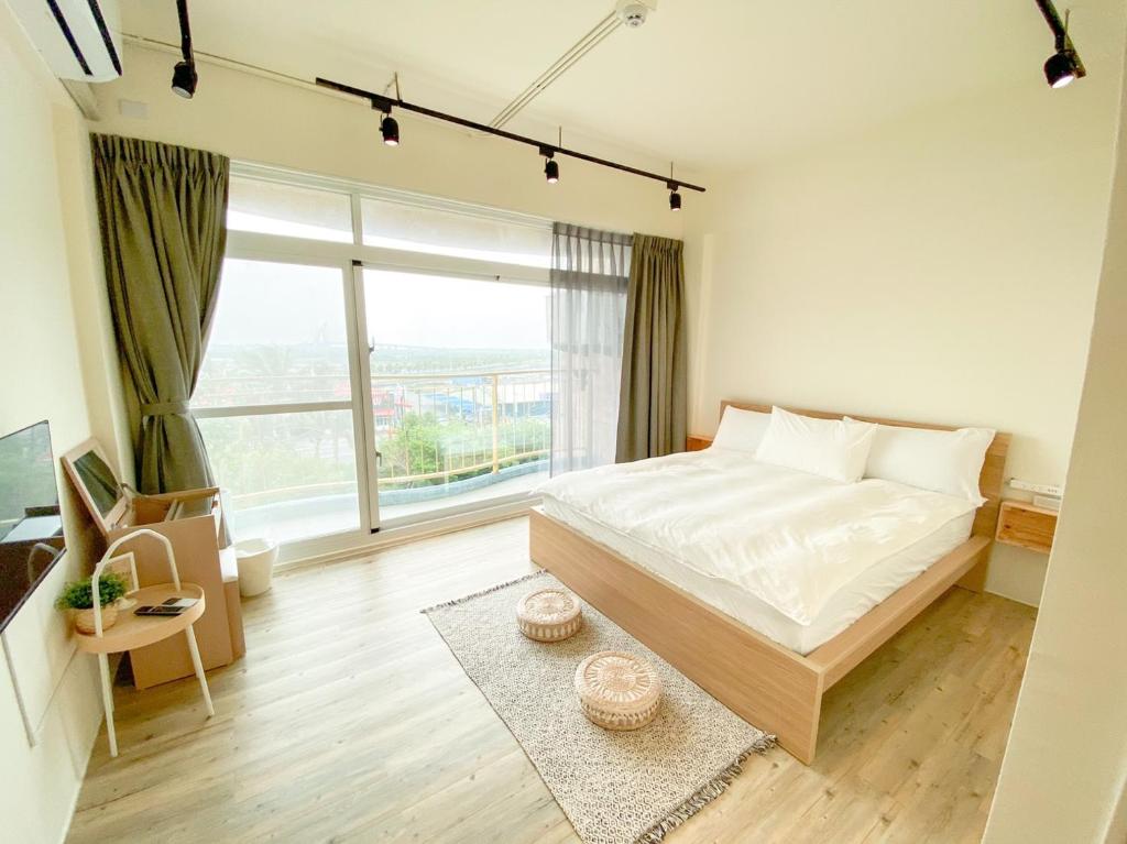 東港的住宿－艾睏khùn行旅，一间卧室设有一张大床和一个大窗户