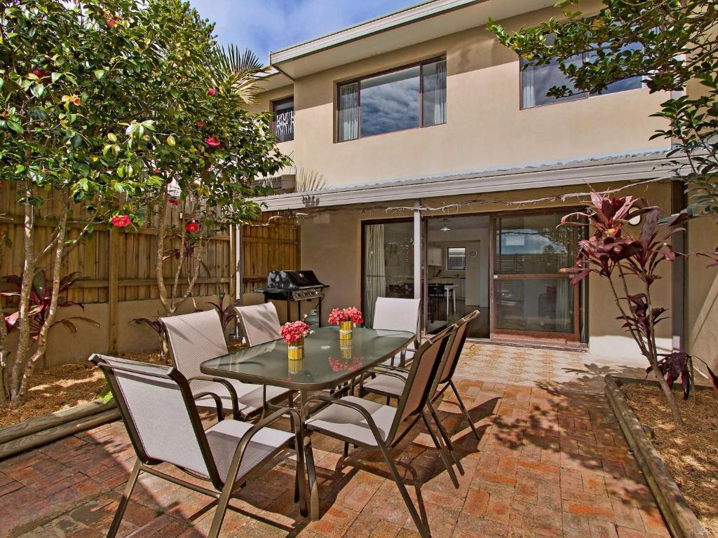 a patio with a table and chairs in front of a house at Family Beachside Getaway with BBQ and Patio in Terrigal