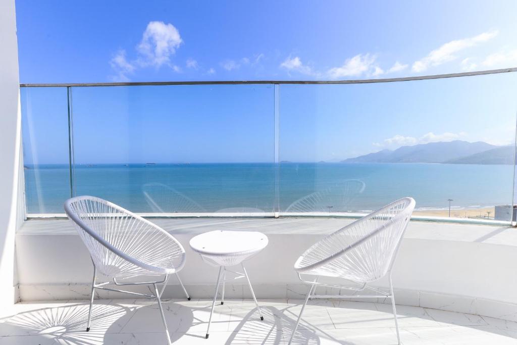 two chairs and a table in front of a large window at TMS-PULLMAN MINH MINH Apartment in Quy Nhon