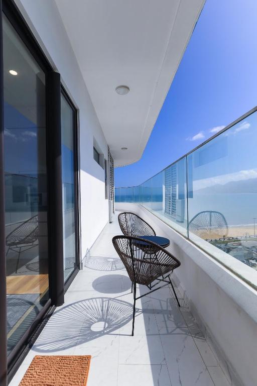 a balcony with two chairs and a view of the ocean at TMS-PULLMAN MINH MINH Apartment in Quy Nhon