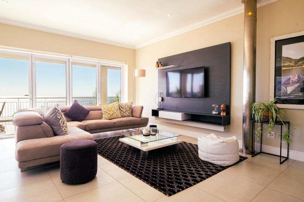 a living room with a couch and a flat screen tv at 3 On Camps Bay in Cape Town