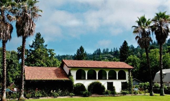 un edificio con techo rojo y palmeras en Spanish Villa Inn en St. Helena