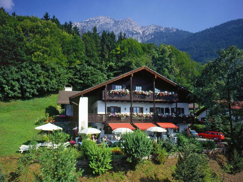 a building with a balcony with people sitting on it at Landhotel Sonnleiten in Bad Reichenhall