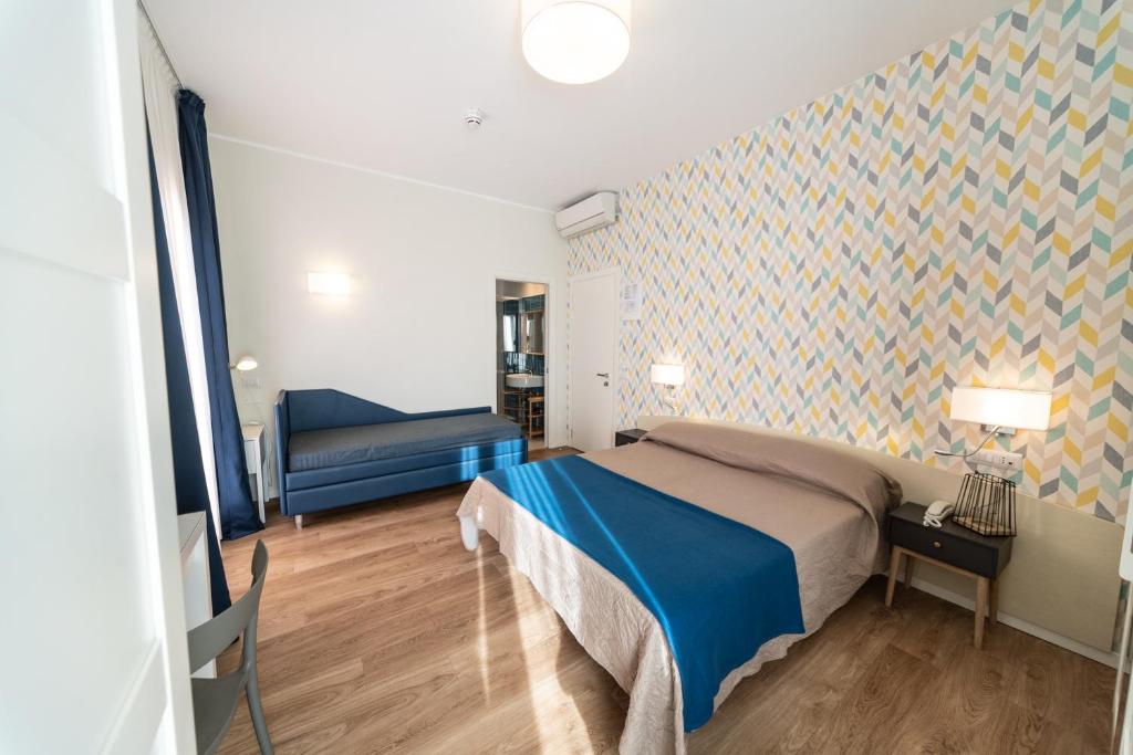 - une chambre avec un lit et un canapé dans l'établissement Hotel Kiss, à Riccione