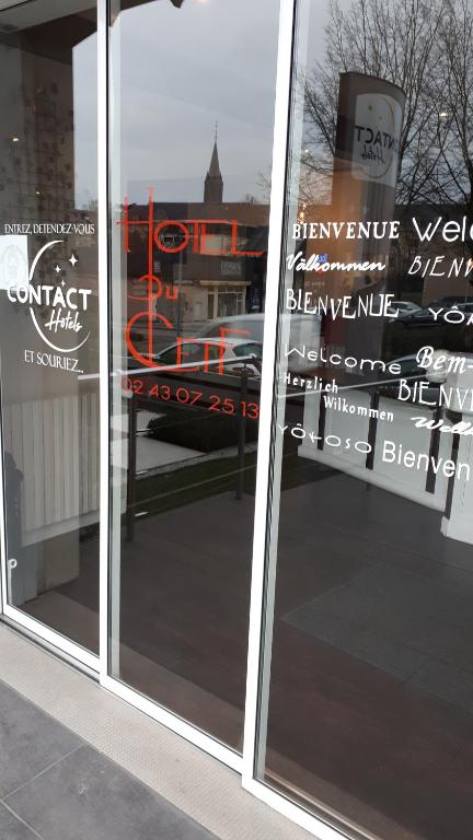 Una ventana de una tienda con letreros. en Contact Hôtel du Cerf, en Château-Gontier