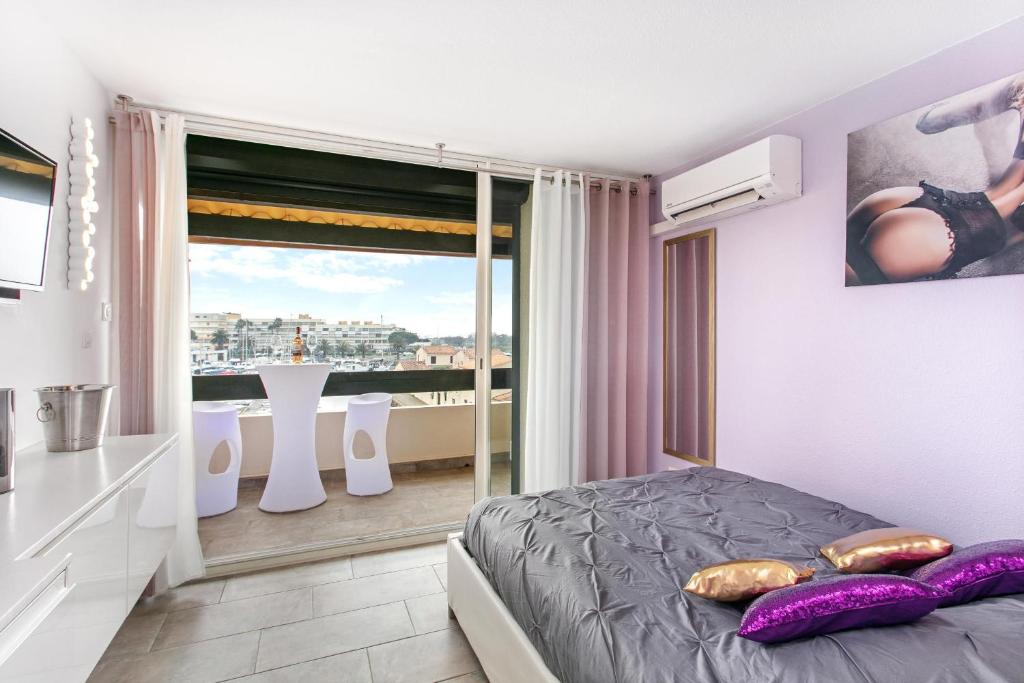 um quarto com uma cama e uma grande janela em Village Naturiste R4N - Le Candi Port Venus Panoramic View em Cap d'Agde