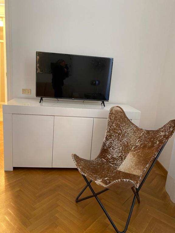 una sedia seduta davanti a una televisione su un mobile bianco di Corso Italia 4 a Bordighera