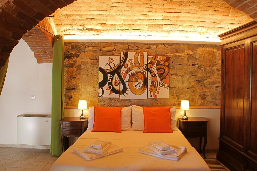 una camera da letto con un letto con cuscini arancioni di I Voltoni di Corsignano a Siena