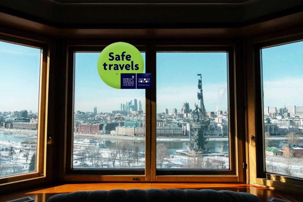 a window with a sign that reads safe travels at President Hotel in Moscow
