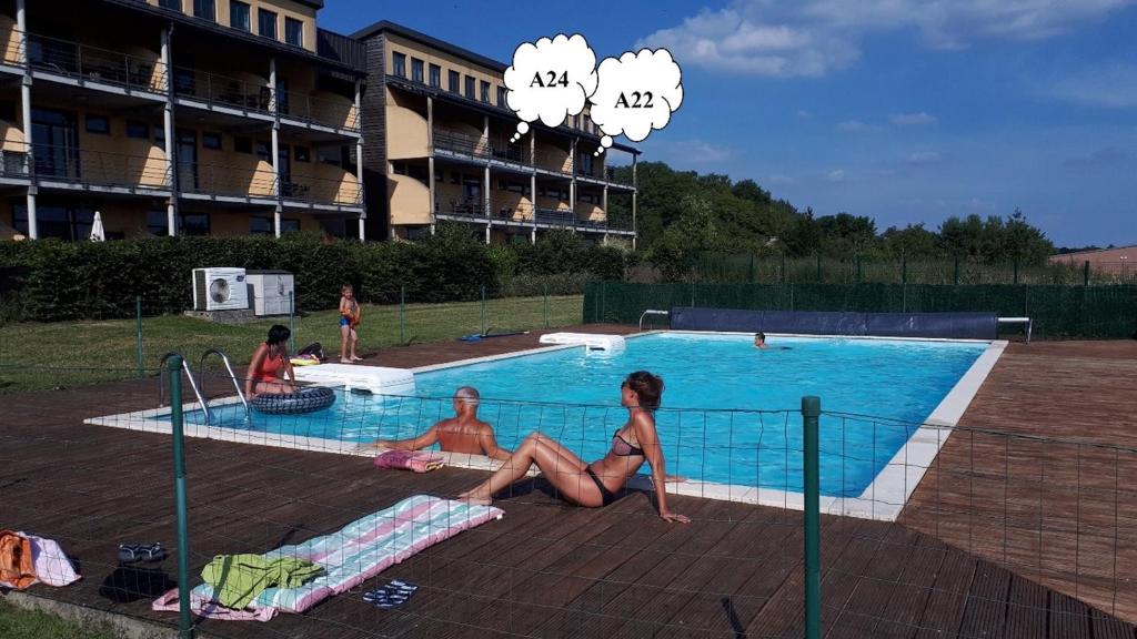 a group of women sitting around a swimming pool at Lacs de l'eau d'heure Amiral 24 in Erpion